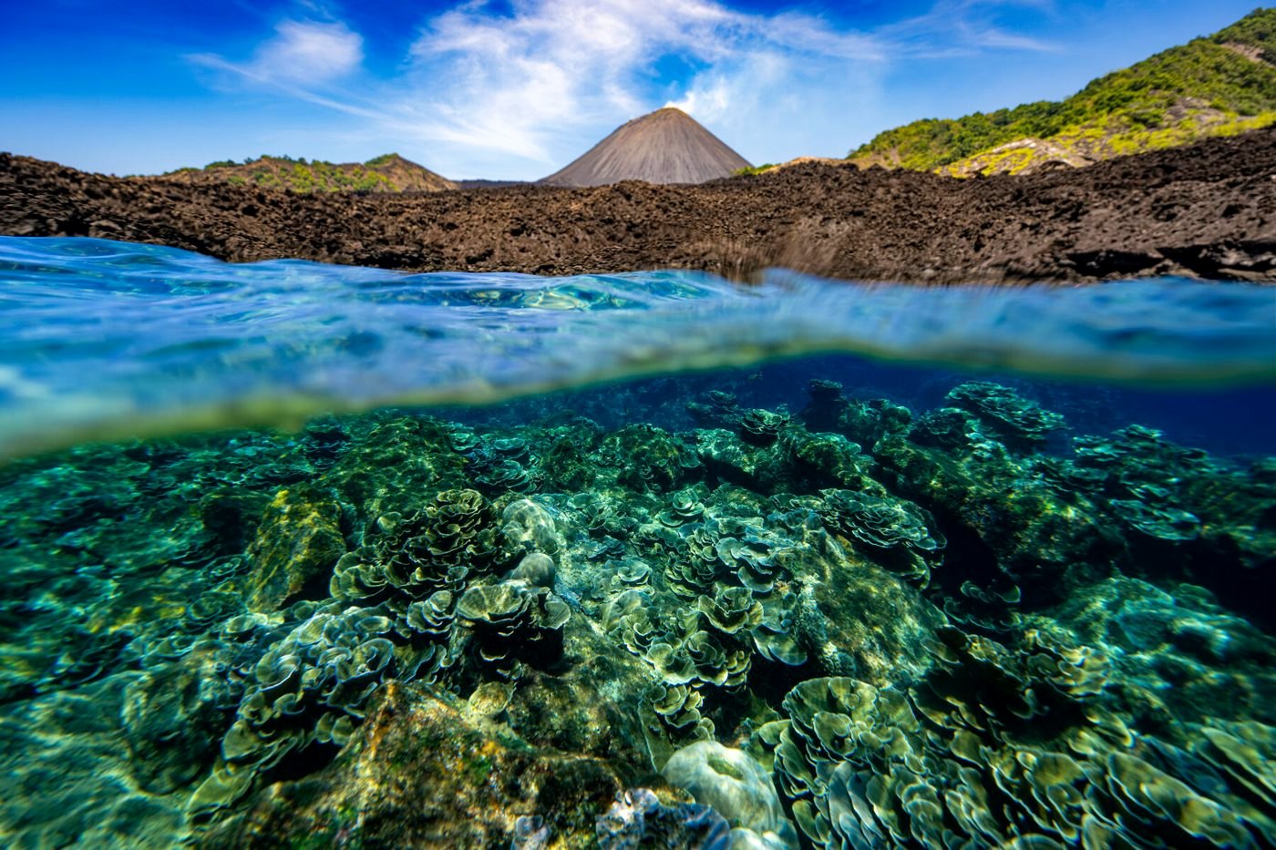 Split shot of reef and a volcanic cone